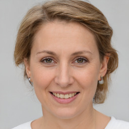 Joyful white adult female with medium  brown hair and green eyes