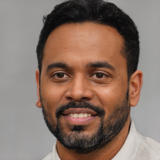 Joyful black young-adult male with short  black hair and brown eyes