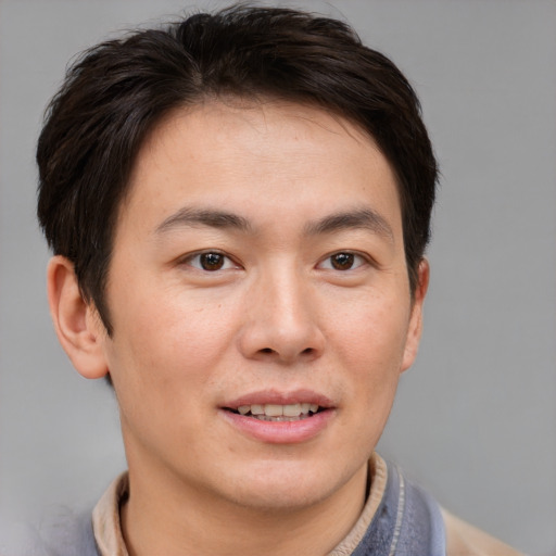 Joyful asian young-adult male with short  brown hair and brown eyes