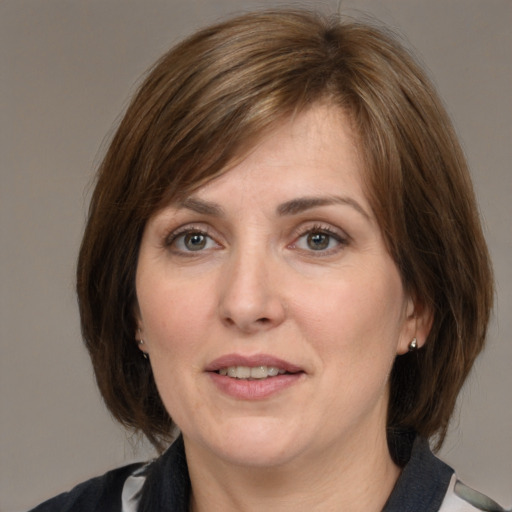 Joyful white adult female with medium  brown hair and grey eyes