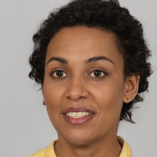 Joyful black adult female with short  brown hair and brown eyes