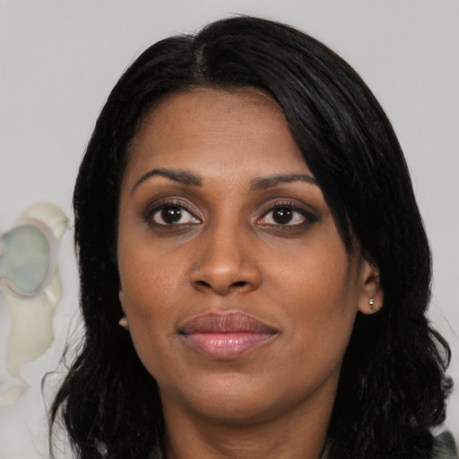 Joyful black young-adult female with long  black hair and brown eyes