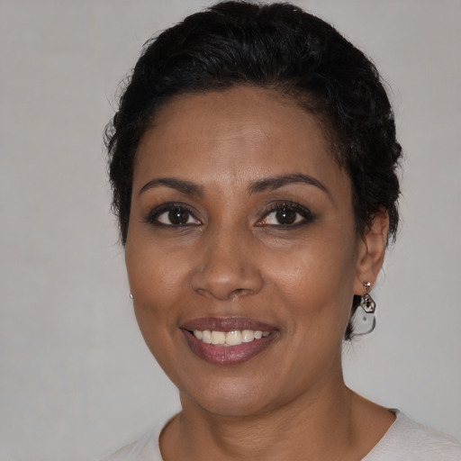 Joyful black adult female with short  black hair and brown eyes