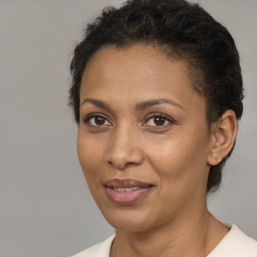 Joyful black adult female with short  brown hair and brown eyes