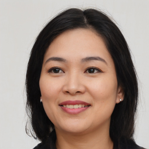 Joyful asian young-adult female with long  brown hair and brown eyes