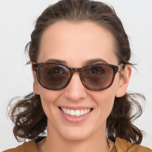 Joyful white young-adult female with medium  brown hair and blue eyes