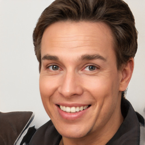 Joyful white adult male with short  brown hair and brown eyes