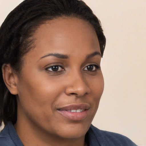 Joyful black young-adult female with long  brown hair and brown eyes