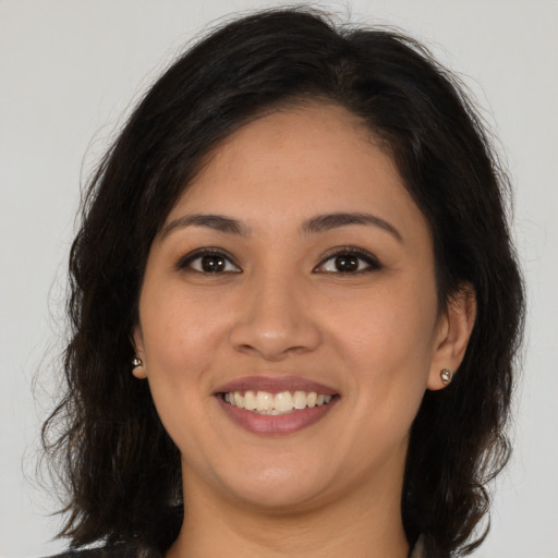 Joyful latino young-adult female with long  brown hair and brown eyes