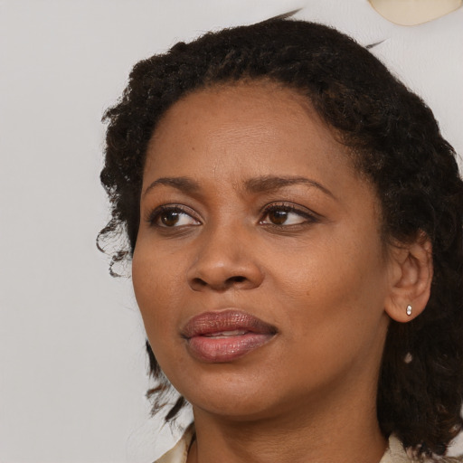 Joyful black adult female with medium  black hair and brown eyes