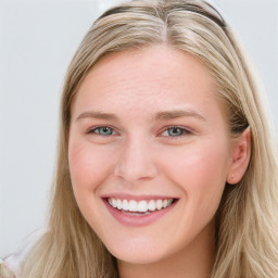 Joyful white young-adult female with long  brown hair and blue eyes