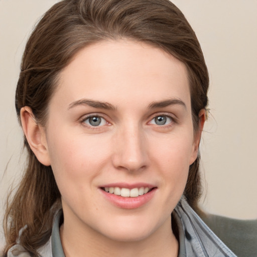 Joyful white young-adult female with medium  brown hair and grey eyes