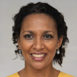 Joyful black adult female with medium  brown hair and brown eyes