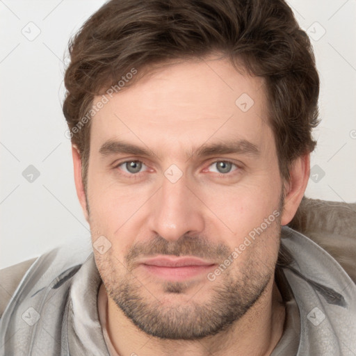 Joyful white young-adult male with short  brown hair and grey eyes