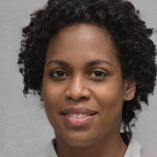 Joyful black young-adult female with short  brown hair and brown eyes