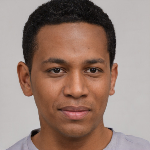 Joyful black young-adult male with short  brown hair and brown eyes