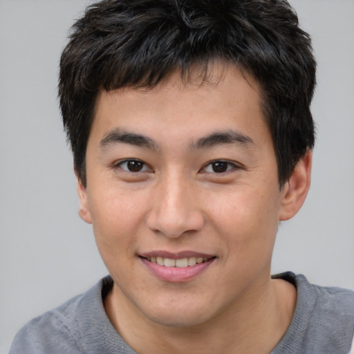 Joyful asian young-adult male with short  brown hair and brown eyes