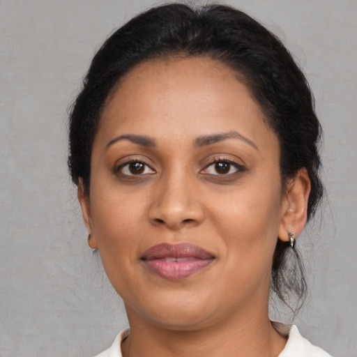 Joyful black adult female with medium  brown hair and brown eyes