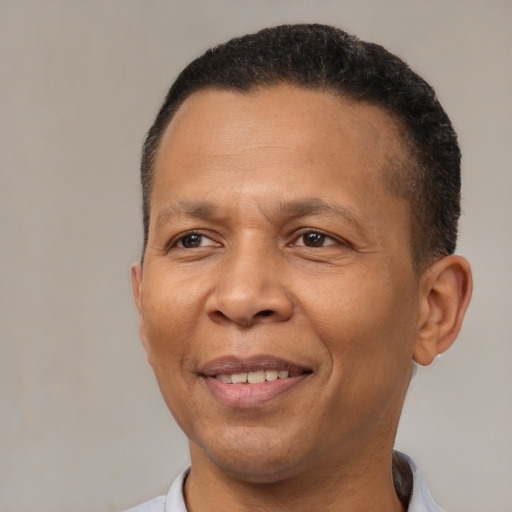 Joyful black adult male with short  brown hair and brown eyes