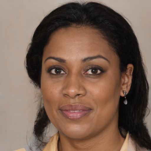 Joyful black adult female with medium  brown hair and brown eyes