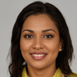 Joyful latino young-adult female with long  brown hair and brown eyes