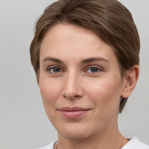 Joyful white young-adult female with short  brown hair and grey eyes