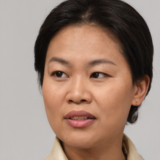 Joyful asian adult female with medium  brown hair and brown eyes