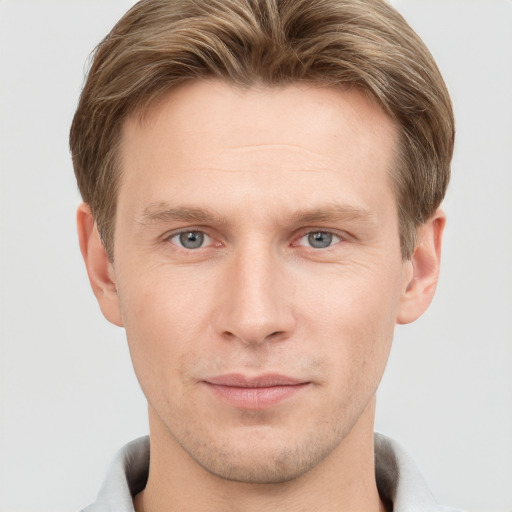 Joyful white young-adult male with short  brown hair and grey eyes