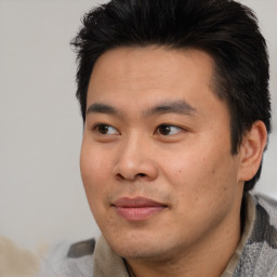 Joyful asian young-adult male with short  brown hair and brown eyes