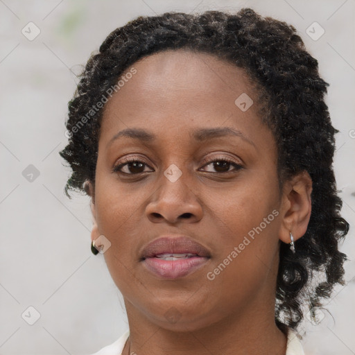 Joyful black adult female with short  brown hair and brown eyes