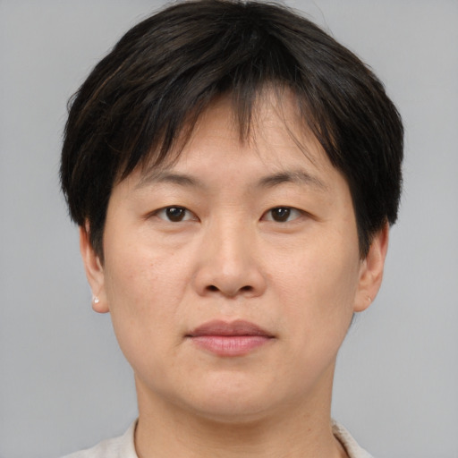 Joyful asian adult male with short  brown hair and brown eyes