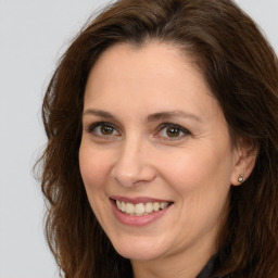 Joyful white adult female with long  brown hair and brown eyes