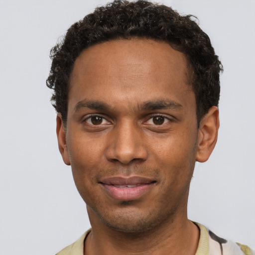 Joyful black young-adult male with short  brown hair and brown eyes