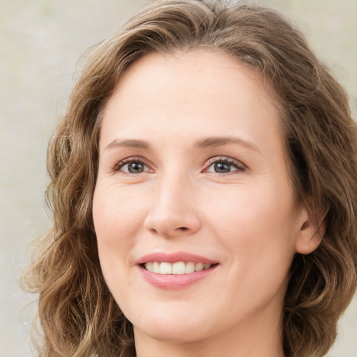 Joyful white young-adult female with medium  brown hair and green eyes