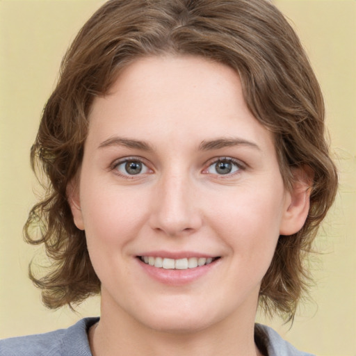 Joyful white young-adult female with medium  brown hair and green eyes