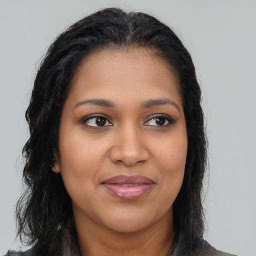 Joyful black young-adult female with long  brown hair and brown eyes