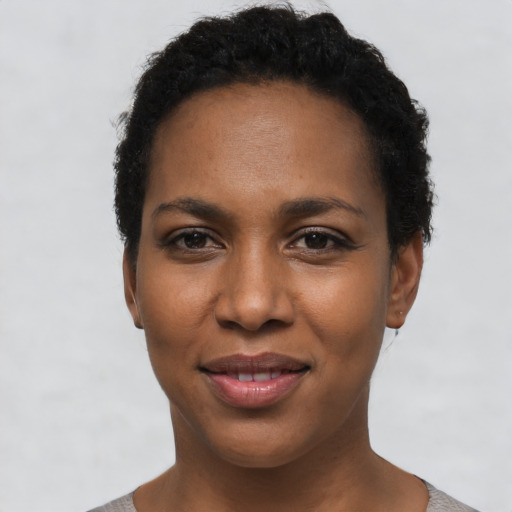 Joyful black young-adult female with short  black hair and brown eyes