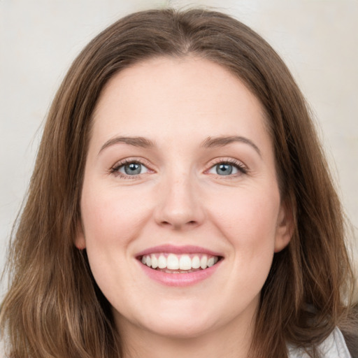 Joyful white young-adult female with long  brown hair and green eyes