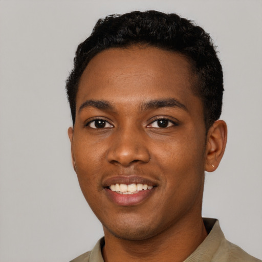 Joyful black young-adult male with short  black hair and brown eyes