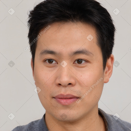 Joyful asian young-adult male with short  brown hair and brown eyes