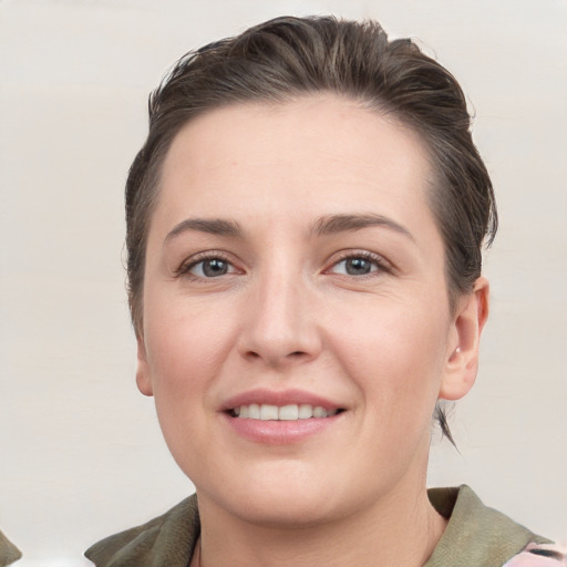 Joyful white young-adult female with medium  brown hair and grey eyes