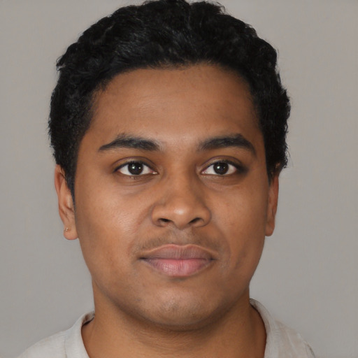 Joyful black young-adult male with short  black hair and brown eyes