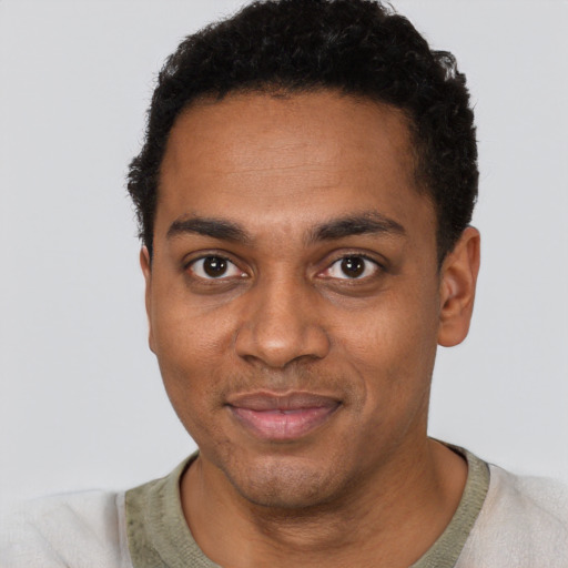 Joyful black young-adult male with short  black hair and brown eyes