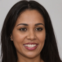 Joyful latino young-adult female with long  brown hair and brown eyes