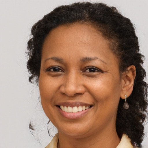 Joyful black adult female with medium  brown hair and brown eyes