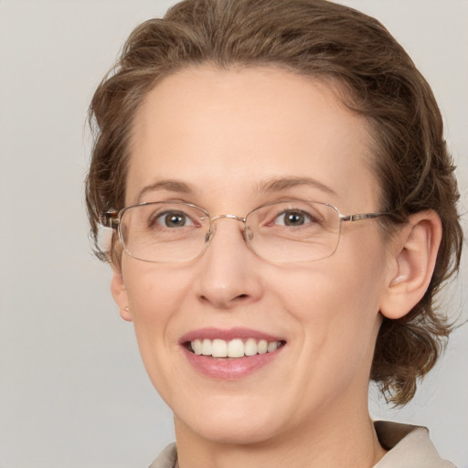 Joyful white adult female with medium  brown hair and green eyes