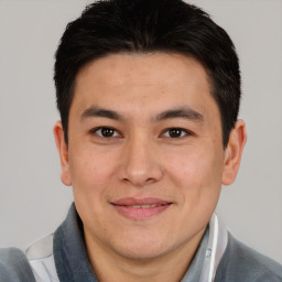 Joyful asian adult male with short  brown hair and brown eyes