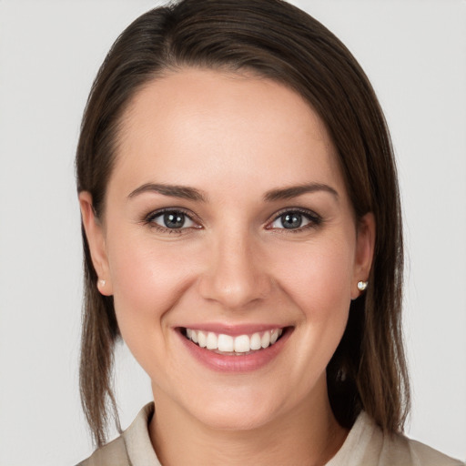 Joyful white young-adult female with medium  brown hair and grey eyes