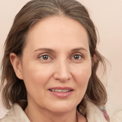 Joyful white adult female with medium  brown hair and grey eyes