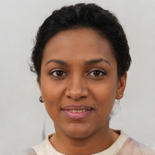 Joyful black adult female with short  brown hair and brown eyes